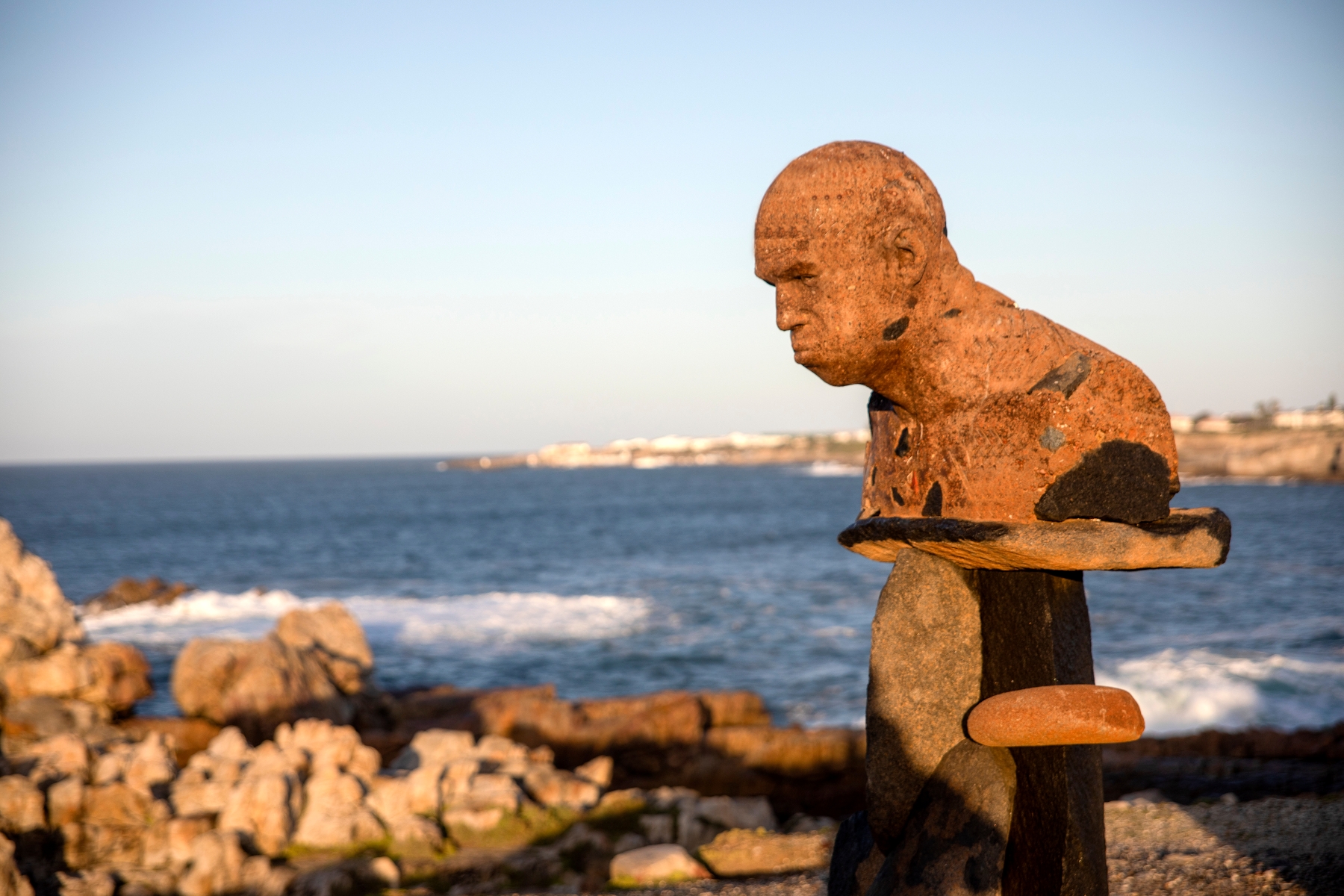 Statue of the famous Angus Taylor A rust-toned coastal sculpture overlooks the sea in Hermanus